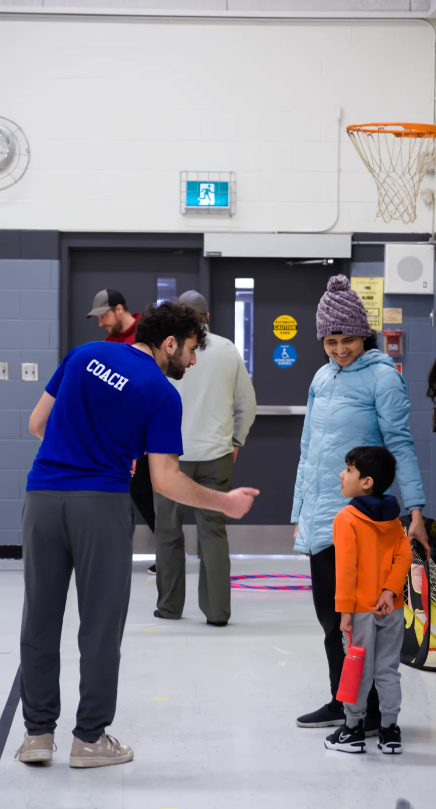 A Junior Athletes coach encouraging a young athlete